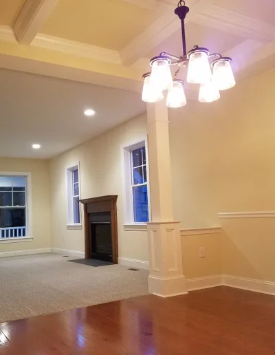An empty living room with hardwood floors and a fireplace.