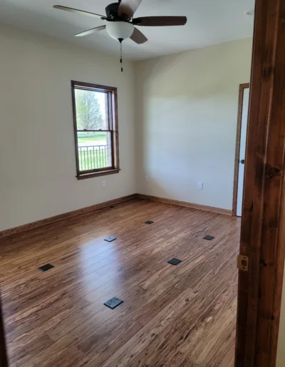 A room with hardwood floors and a ceiling fan.