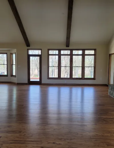 An empty living room with wood floors and a fireplace.