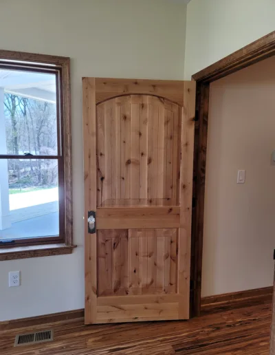 A wooden door in a room with hardwood floors.