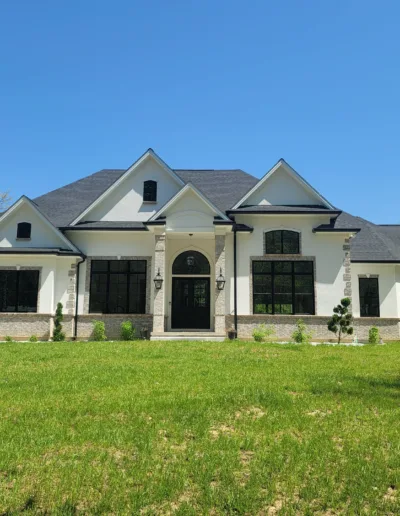 A white and black home with a grassy yard.