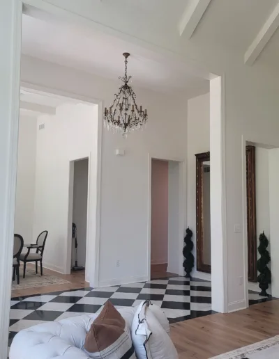 A white and black living room with a chandelier.