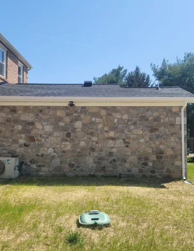 A backyard with an air conditioner and a brick wall.