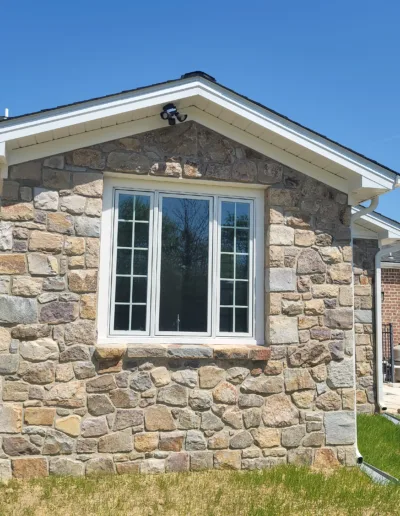 A house with a stone wall and a window.