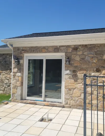 A stone patio with a sliding glass door.