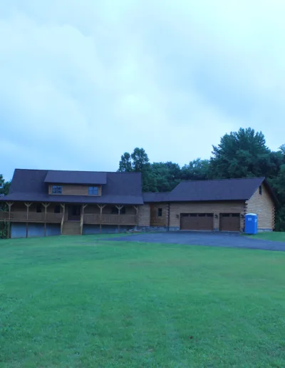 A large house in the middle of a grassy field.