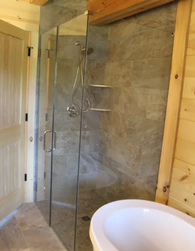 A bathroom with a glass shower stall.