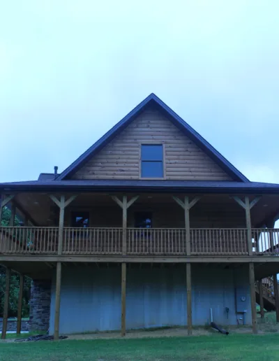 A large log home with a porch.