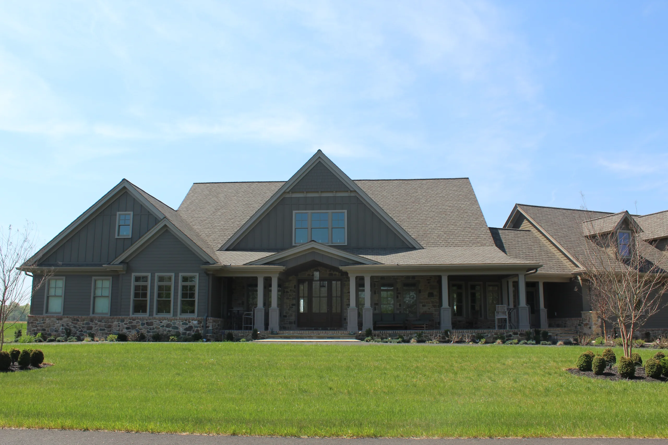 A home with a large front yard and a large front porch.