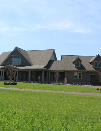 A large house in the middle of a grassy field.