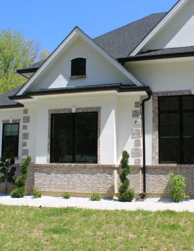 A white and black home with a large front yard.