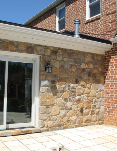 A dog is laying on a concrete floor in front of a house.