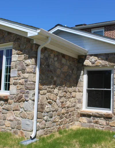 A brick house with a stone wall and a window.
